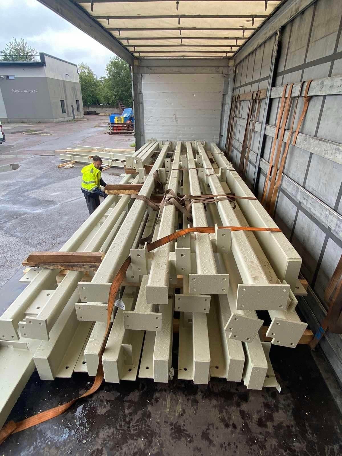 Painted steel beams strapped inside a curtainsider trailer