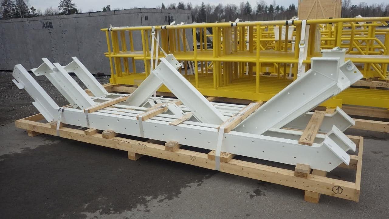 White-painted steel frames on timber bearers, yellow frames behind them